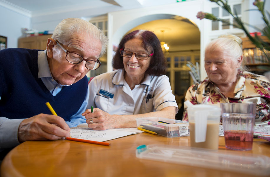 carer assisting two service users with activities